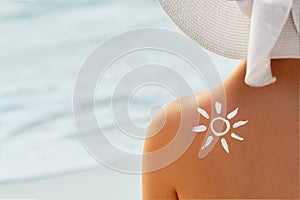 Woman With Suntan Lotion At The Beach In Form Of The Sun. Portrait Of Female With the Drawn Sun On a Shoulder