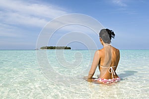 Woman suntanning on white sand beach