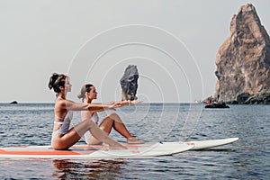 Woman sup yoga. Happy sporty woman practising yoga pilates on paddle sup surfboard. Female stretching doing workout on