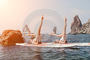 Woman sup yoga. Happy sporty woman practising yoga pilates on paddle sup surfboard. Female stretching doing workout on