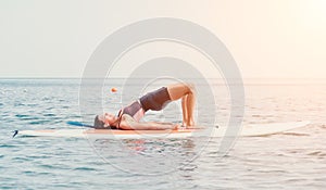 Woman sup yoga. Happy young sporty woman practising yoga pilates on paddle sup surfboard. Female stretching doing