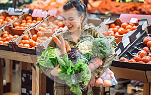 Woman in the supermarket. Beautiful young woman shopping in a supermarket and buying fresh organic vegetables