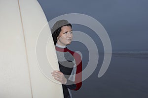 Woman With Surfboard Looking Away At Beach