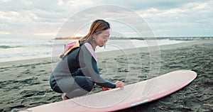 Woman, surfboard wax and happy by ocean, thinking and ready for workout, training or wellness in morning. Person, surfer