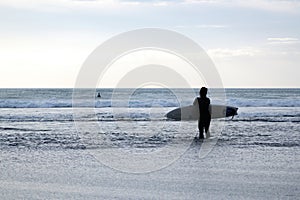 Woman surfer in black wetsuit