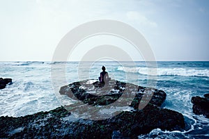 Woman surfer meditation at the seaside cliff edge
