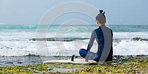 Woman surfer sit on reef