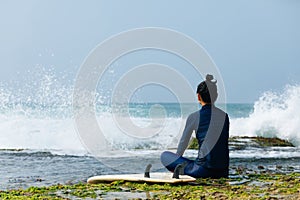 Woman surfer sit on reef