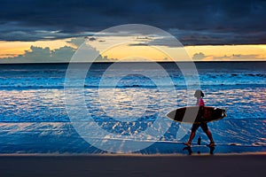 Woman surfer at sunset. Bali