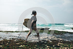 Woman surfer walking with surfboard