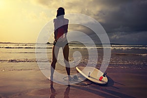 Woman surfer warming up on the beach