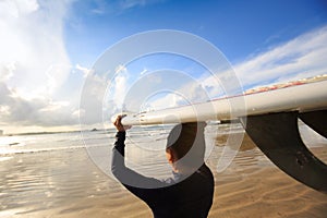 Woman surfer with white surfboard on a beach