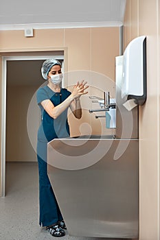 woman surgeon, washes her hands in the preoperative unit, the surgeon disinfects his hands before the operation.