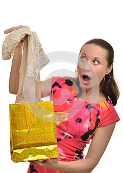 Woman with surprise examines new clothes obtained as a gift