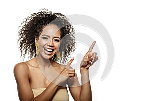 Woman surprise showing, presenting product. Beauty Shocked african american girl with afro hair pointing to the side at copy space