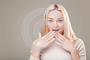 Woman surprise showing product .Beautiful girl with curly hair pointing to side