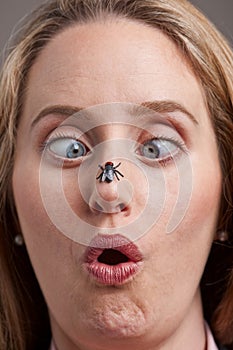 Woman surprised by fly on her nose