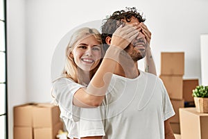 Woman surprising hes boyfriend covering eyes at new home