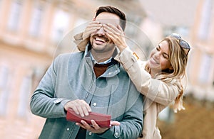 Woman surprising his boyfriend with a gift.