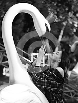 Woman and swan on green sunny park background