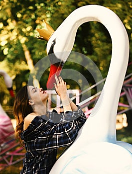 Woman and swan on green sunny park background