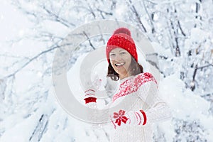 Woman in sweater playing snow ball fight in winter