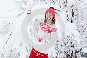 Woman in sweater playing snow ball fight in winter