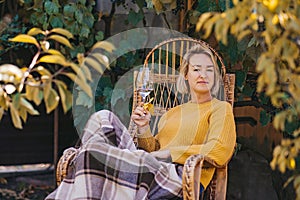 woman in sweater reads a book and drinking wine in terrace