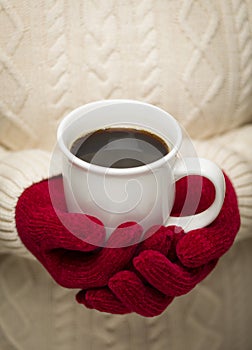 Woman in Sweater with Red Mittens Holding Cup of Coffee photo