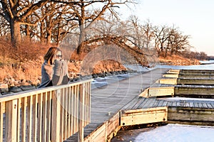 Woman standing on wooden bridge in winter
