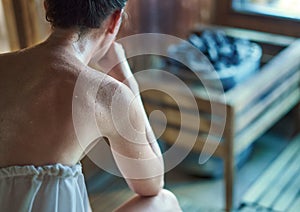 Woman sweating in finnish sauna