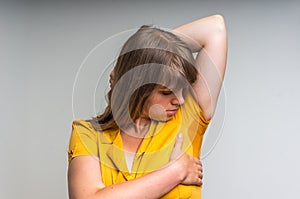 Woman with sweating under armpit in yellow dress