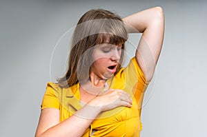Woman with sweating under armpit in yellow dress photo