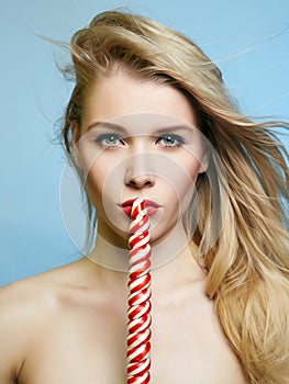 Woman with Sweet Candy. Blonde Girl eating lollipop