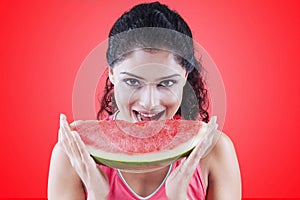 Woman with sweet watermelon on red background