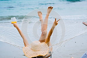 Woman in swimimg suit relax laying on hammock on beach