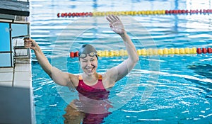 Woman swimmer happy at the finish in the pool