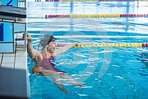 Woman swimmer happy at the finish in the pool