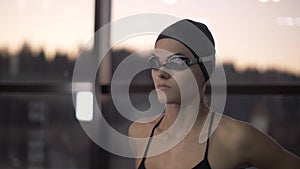 Woman swimmer putting goggles on face for underwater swimming in pool