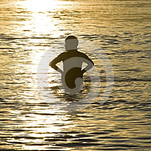 Woman swimmer silhouette at sunset