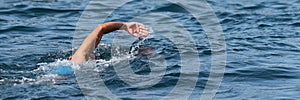 Woman swimmer swimming crawl in blue sea
