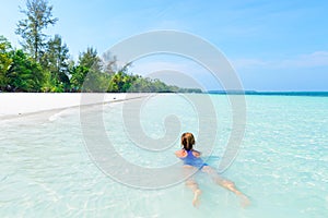 Woman swimming in caribbean sea turquoise transparent water. Tropical beach in the Kei Islands Moluccas, summer tourist