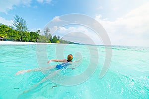 Woman swimming in caribbean sea turquoise transparent water. Tropical beach in the Kei Islands Moluccas, summer tourist
