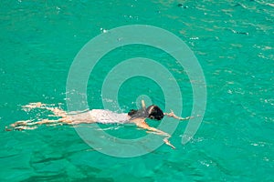 Woman swimming and diving in the exotic beaches of Zakynthos island in Greece.