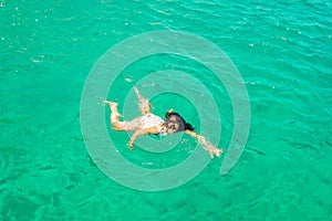 Woman swimming in the exotic beaches of Zakynthos island in Greece.