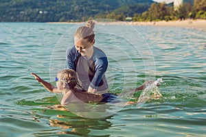 Woman swimming instructor for children is teaching a happy boy t