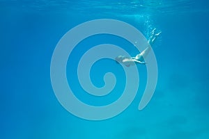 Woman swimming in open sea. Close up underwater photo. Diving girl in open water.