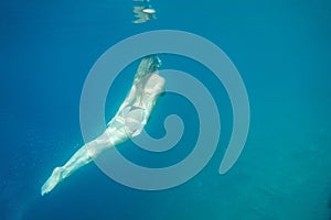 Woman swimming in open sea. Close up underwater photo. Diving girl in open water.
