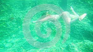 Woman swimming in open sea. Close up underwater photo. Diving girl in open water