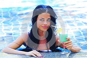 Woman in swimming pool with cocktail